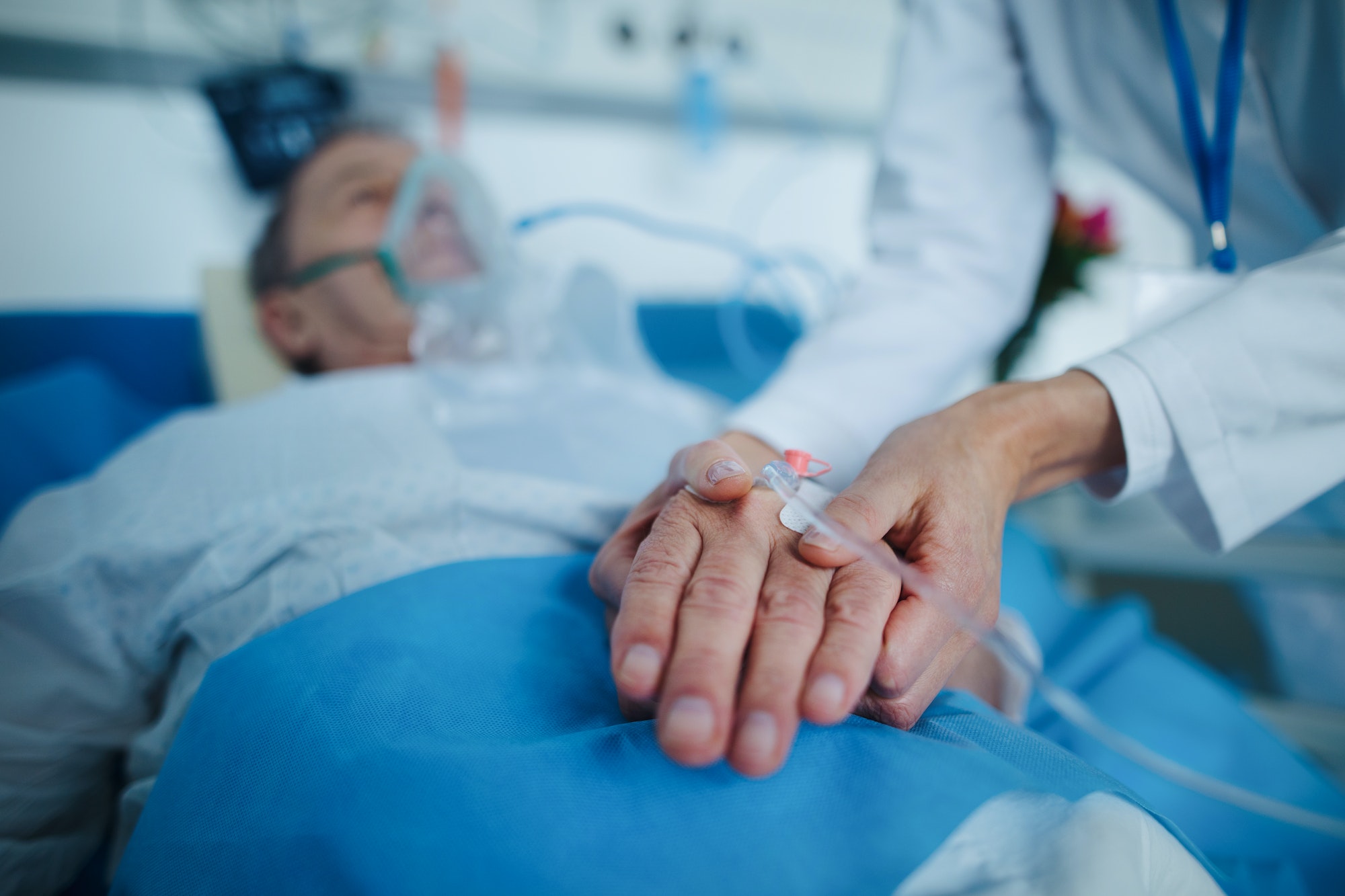 Close-up of nurse applying cannula at patients hand.